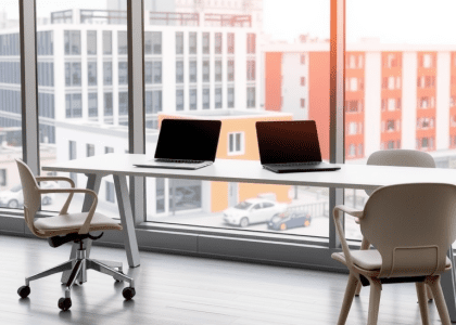 "Modern office desk featuring two laptops and three chairs surrounding it, positioned in front of a large window, showcasing luxury office furniture and contemporary office design inspiration."